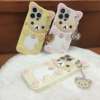 Three cartoon bear phone cases with keychains on a white surface.