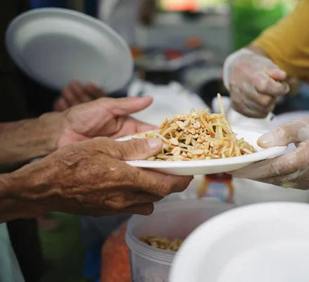 Server handing food to an old person